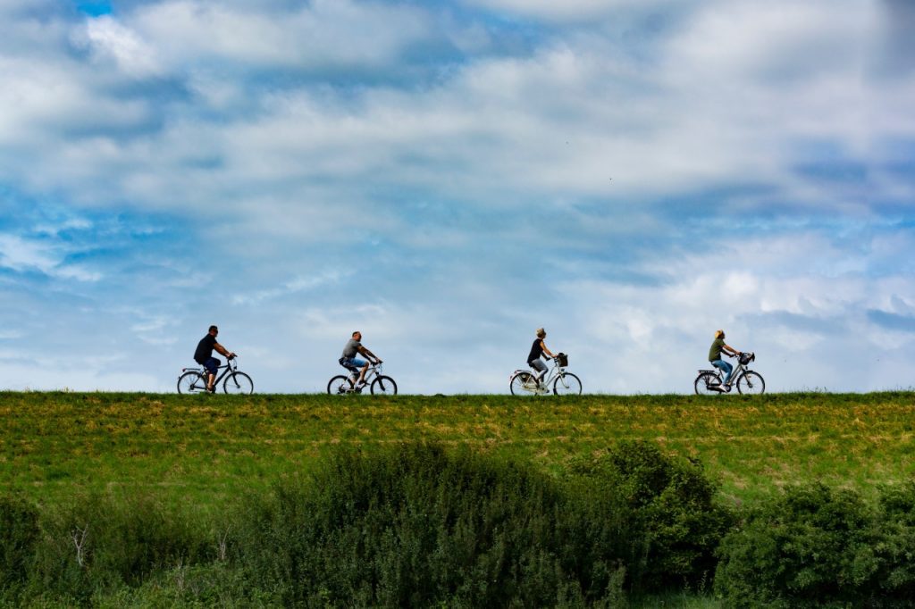 4 mensen fietsen over de dijk