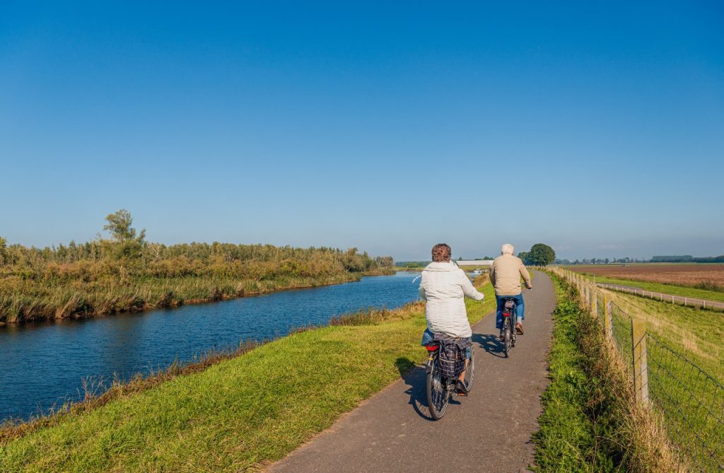 fietsende mensen langs de maas